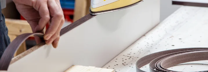 Person klebt Furnier auf Holz